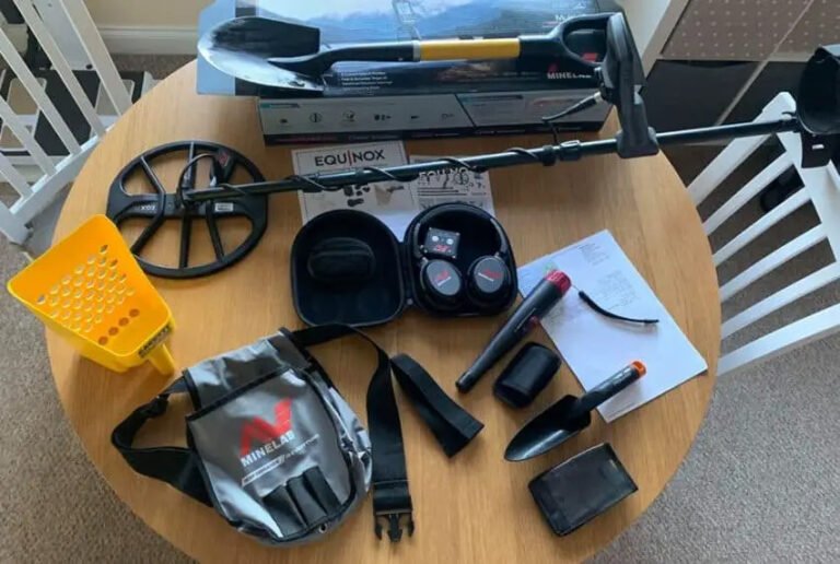 All the required tools for metal detecting laid out on a table.